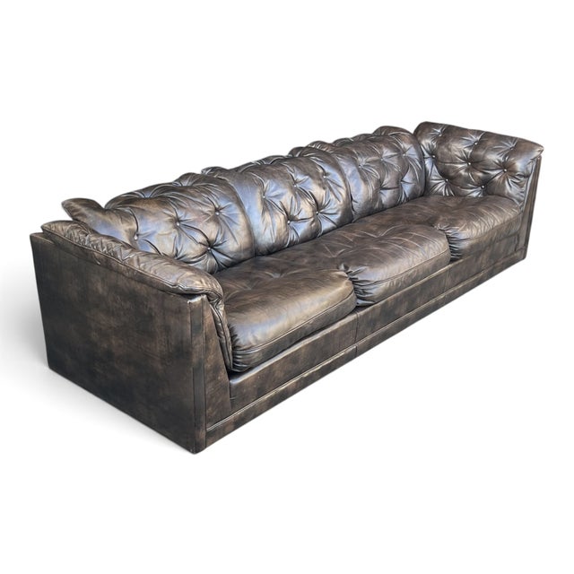 A bold and inviting statement piece, this vintage leather sofa combines generous proportions with distinctive tufted...