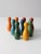 This is a set of vintage wooden tabletop bowling skittles. The colorful set features nine pins in bright playful colors.