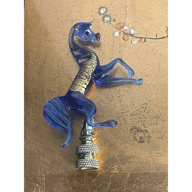 Italian blown cobalt glass with gold speckles horse sculpture mounted on a brass base as lamp finial.