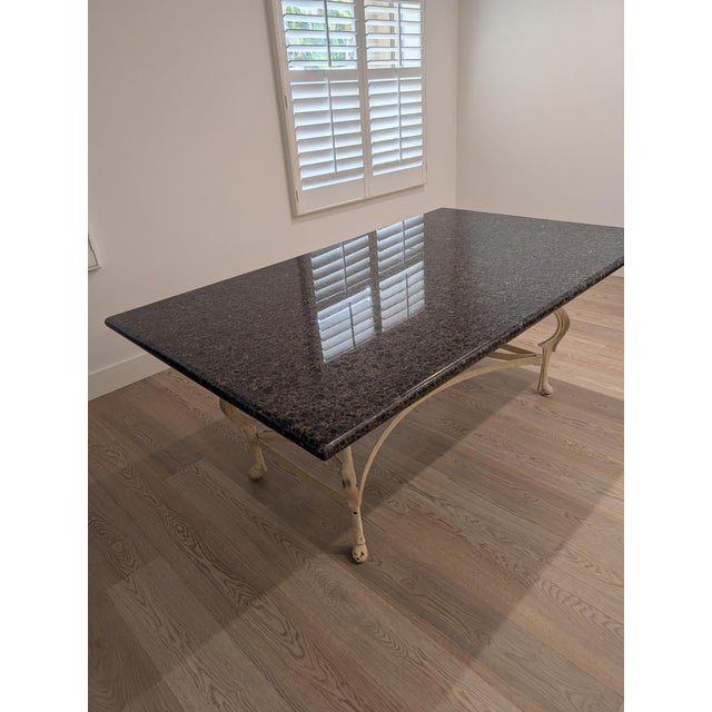 An exceptional Maison Jansen-style dining table featuring a substantial polished marble top supported by an extraordinary...