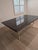 An exceptional Maison Jansen-style dining table featuring a substantial polished marble top supported by an extraordinary...