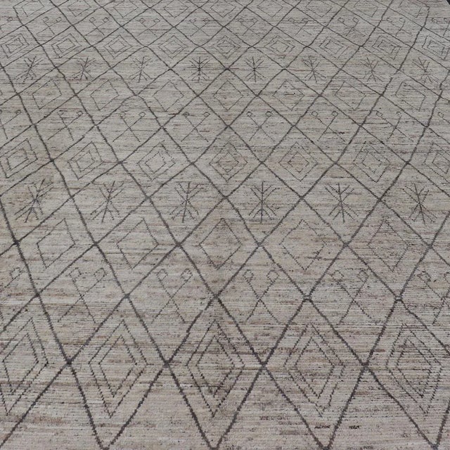 Measures: 10'2 x 13'6. This modern casual tribal rug has been hand-knotted. The rug features a modern all-over sub-...