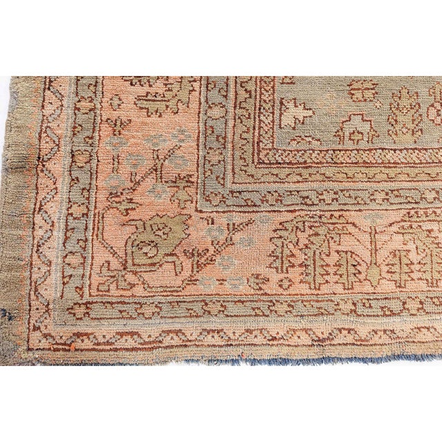 This antique Turkish Oushak rug (circa 1920) showcases a botanical and casual design dominated by soft greens and pink...