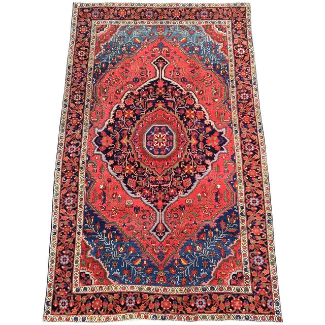 A fabulous antique Sarouk Ferahan rug, handwoven circa 1910 with a large medallion design on a rich tomato red field....