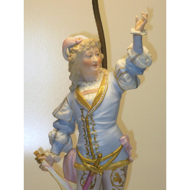 This is an antique table lamp. It's a really stunning and rather rare art figurine. The young man is wearing a superb and...