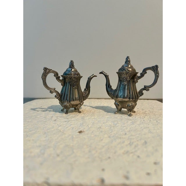 These are vintage Godinger Silver Art Co. teapot/coffee pot shaped salt and pepper shakers. The set includes a sale shaker...