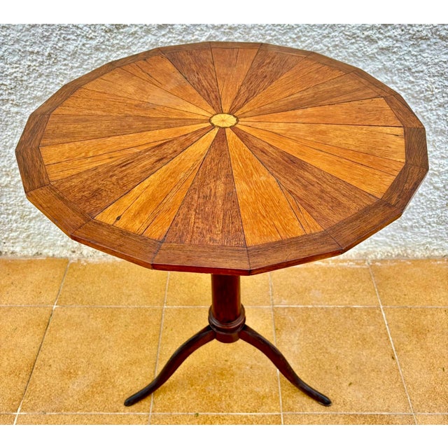 Elegant Spanish side table crafted during the mid-20th century, featuring a beautifully executed circular marquetry top...