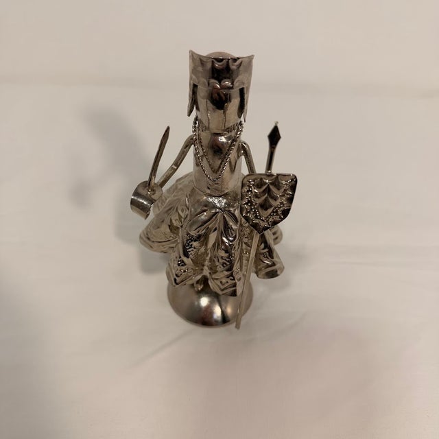 Vintage silver-tone metal figurine depicts a stylized female warrior or queen, intricately detailed with a textured...