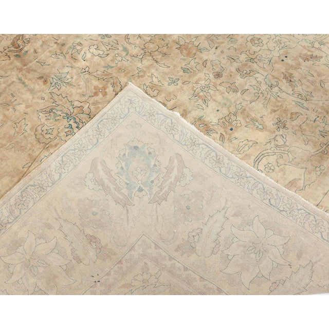 This early 20th century antique Indian rug features a subtle all-over trellis design of split-leaf tendrils in inky blue...