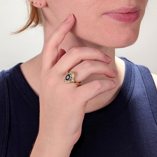 A fine vintage gold, sapphire, and diamond ring In 14 karat yellow gold. With a central bezel-set 1.50ct± oval mixed cut...