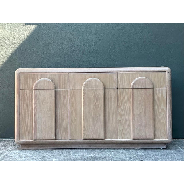 This striking Postmodern credenza is a masterclass in 1980s architectural design, featuring a soft waterfall silhouette...