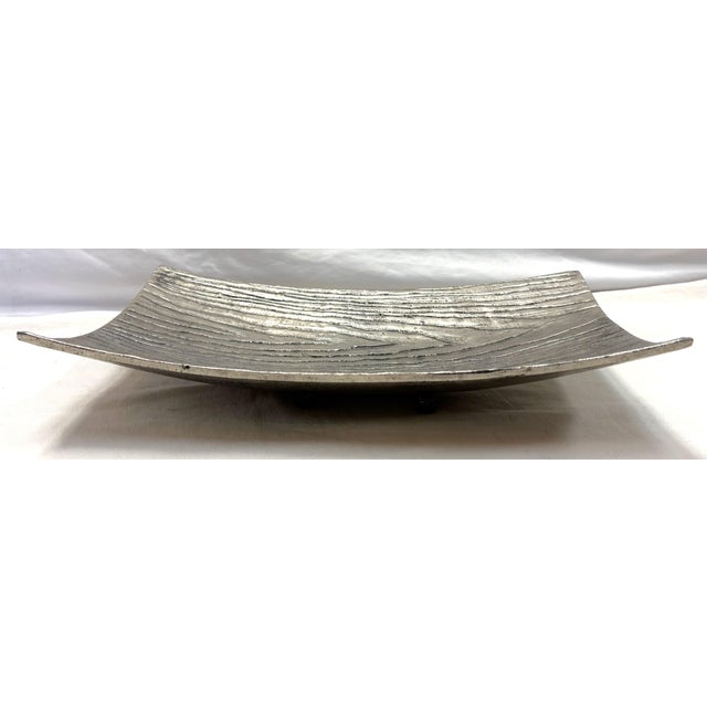 Mid Century Modern style platter from the early 21st century. The piece is made of metal in a silver color with a faux...