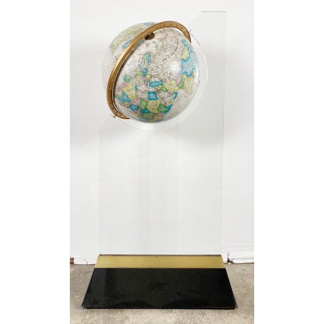 Vintage Postmodern style globe on acrylic and brass floor stand. Incredible presence with a chic presentation. Globe spins...