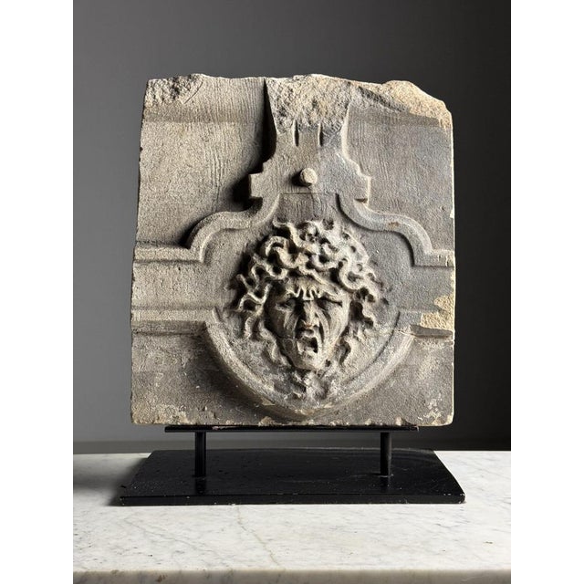 Carved stone fragment on custom black stand. Originating from the 18th century. Pictured is Medusa. Medusa is a figure...
