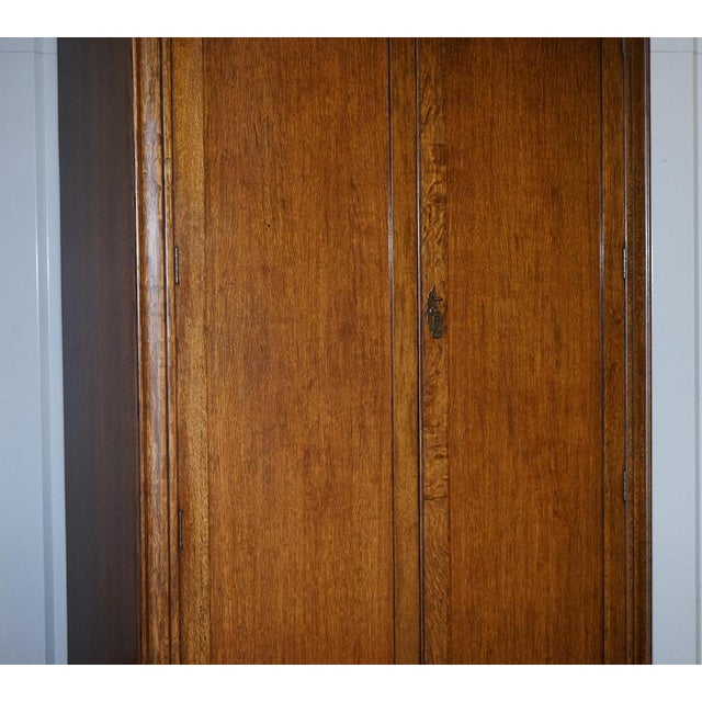 Antiques of London This handsome antique English wardrobe is crafted from solid oak, offering both substance and timeless...