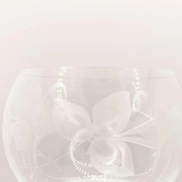 A pair of green glass etched wine glasses. The body of these pretty glasses is transparent and etched with leaves and...