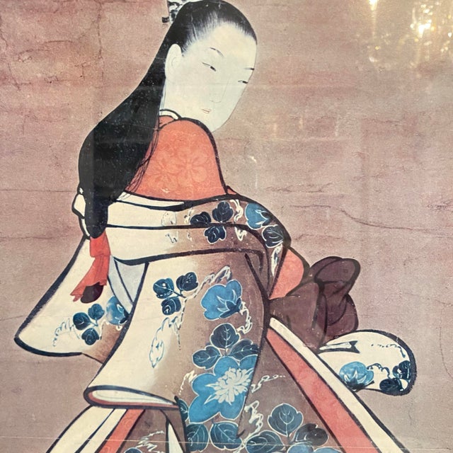 Attractive portrait of a courtesan wearing a kimono patterned with large blue blossoms and leaves over red under robe. Her...