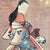 Attractive portrait of a courtesan wearing a kimono patterned with large blue blossoms and leaves over red under robe. Her...