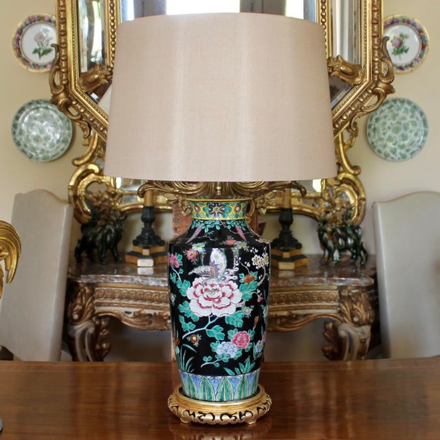 A fine and dramatically decorated black ground Famille Noir porcelain vase with prunus branches, peony flowers and...