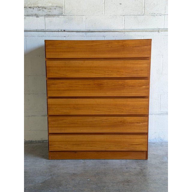 This tall dresser features a clean minimalist profile with six spacious storage drawers. The flush drawer fronts create a...