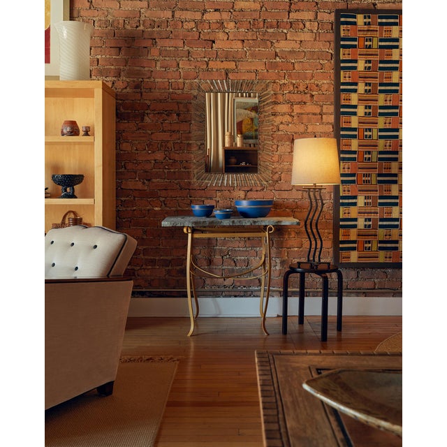 This console table pairs a natural slate top in an organic, freeform shape with a painted iron base in a warm yellow hue....