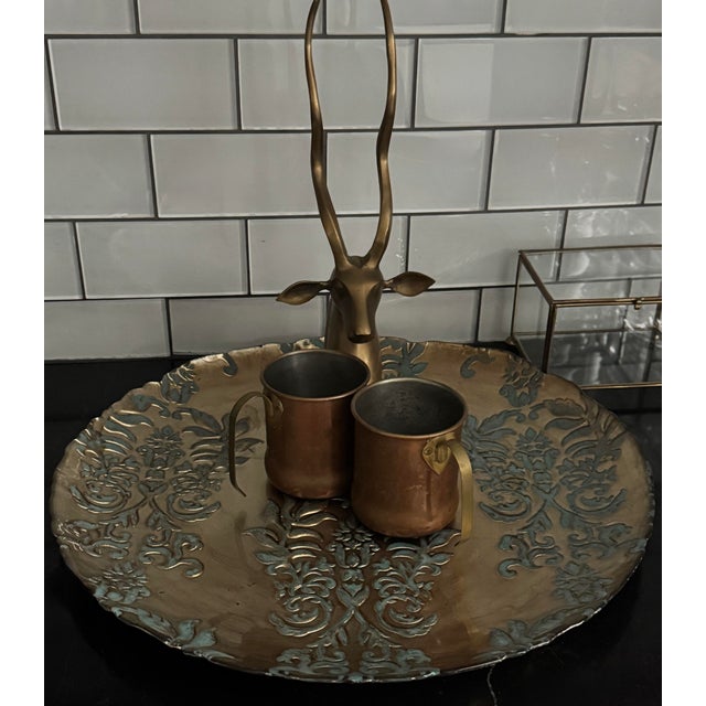 Monumental mid-century brass charger with raised verdigris damask relief. Measuring 18 inches in diameter, this piece...