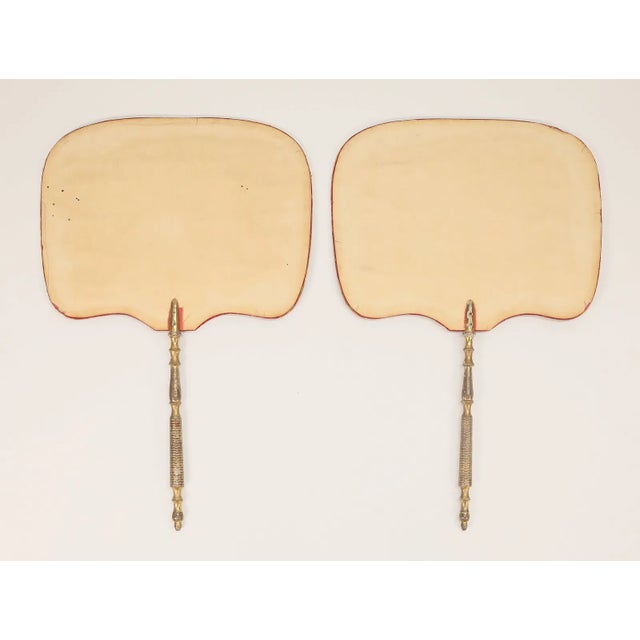 A charming pair of antique theorem-decorated hand fans, each featuring hand-painted floral designs on velvet with paper...