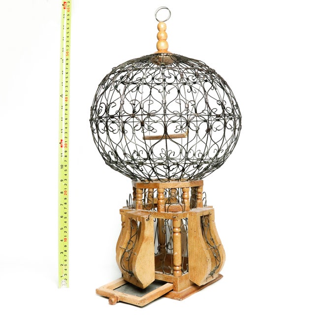 20th Century Victorian style wood and iron "Balloon" bird cage & feeder. This ornamental piece features stained wood with...