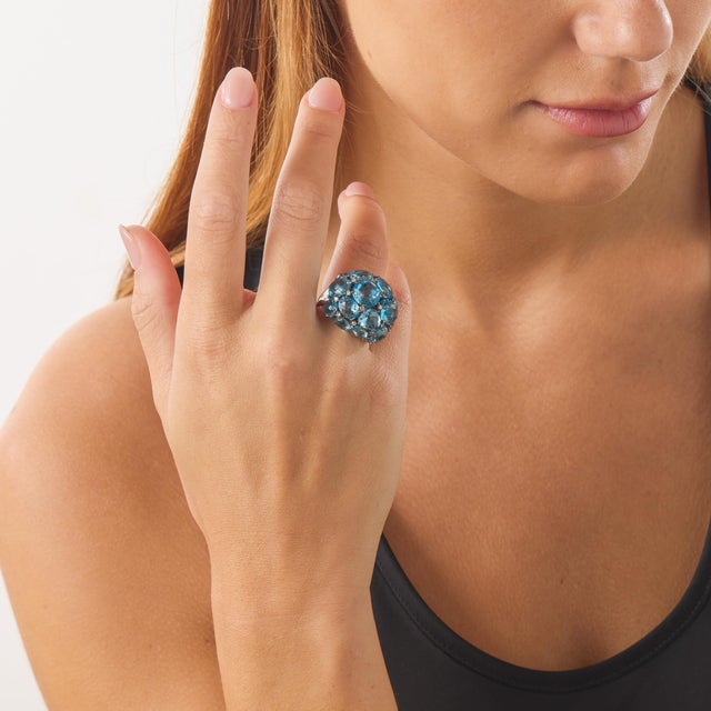 This bold vintage cocktail ring showcases a dramatic cluster composition of 16 mixed cut blue topaz stones totaling...