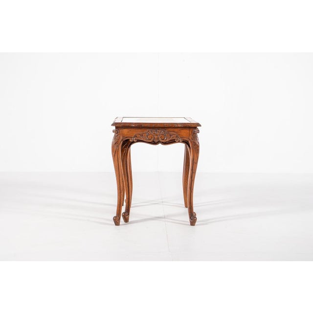Very elegant vintage nesting tables in the style of Queen Anne with hand carved decor on the legs and cane and glass top....