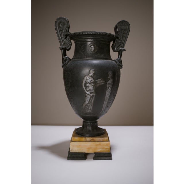 Elegant pair of neoclassical decorative vases in patinated spelter, finished to resemble excavated bronze, and resting on...