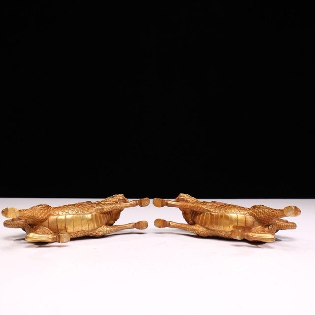 A magnificent pair of solid-copper gilded qilin statues, each captured in a dynamic running posture with finely detailed...