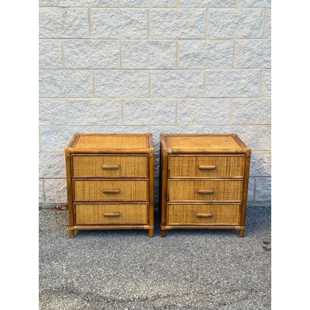 A pair of rattan and bamboo nightstands or side tables, each with three drawers and finely woven cane drawer fronts.