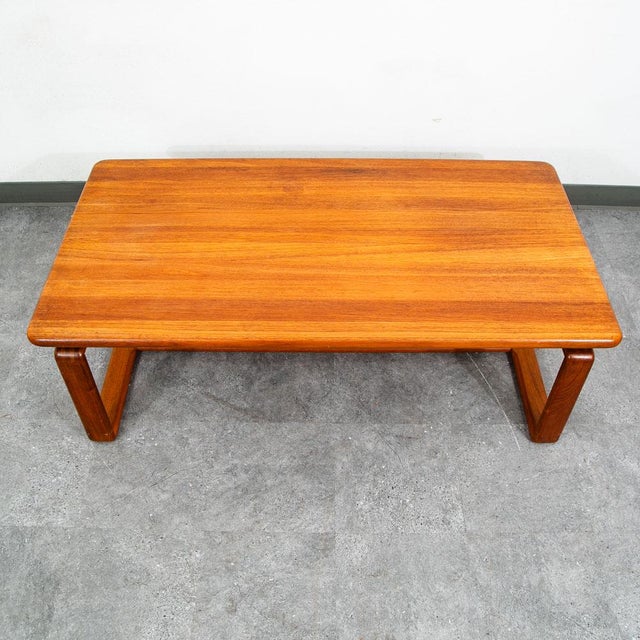Solid teak coffee table by KB Furniture. Dovetailed teak sled style legs. Unique style and design.