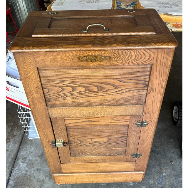Antique Golden-Oak Ice Box with metal hardware. Porcelain lining was long ago removed. Has been serving as a liquor...