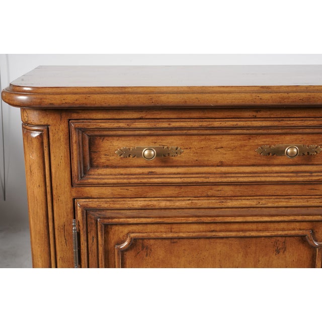 A handsome contemporary walnut buffet inspired by classic French Provincial cabinetry. Its warm, deliberately aged finish,...