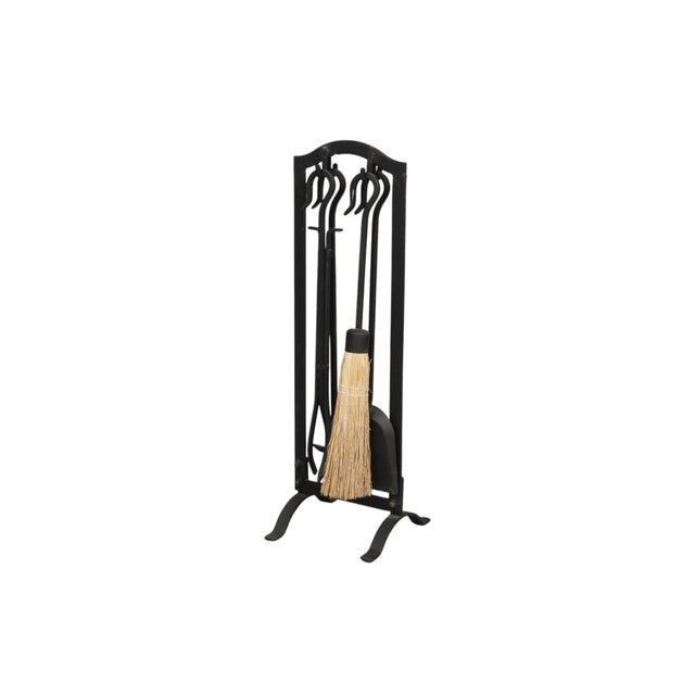 A set of black cast iron fireplace tools. A shovel, poker, tongs, and broom each have a hook wrought on the end of their...