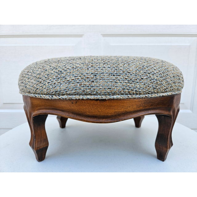 This beautiful footstool features tweed blue and brown fabric and carved legs. The oval footstool is in very good vintage...