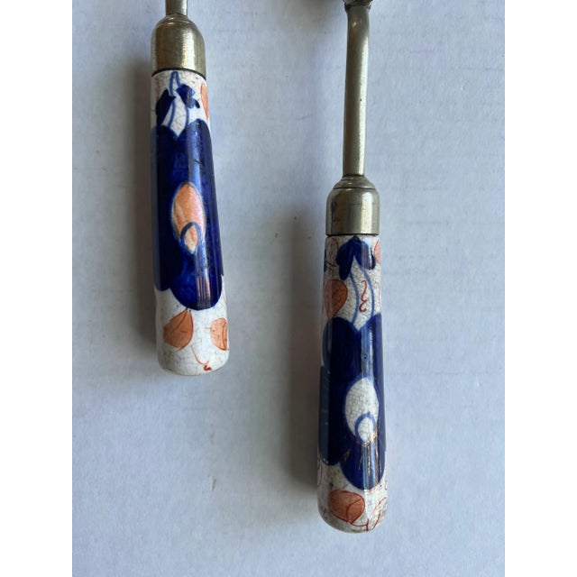 Vintage blue, white and orange Chinoiserie salad utensils. Marked S N and What looks like a Bee. Measures 10.5 l x 1.85w x...