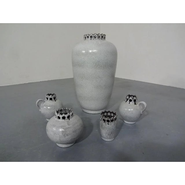 Five made of ceramic vases from the 1960s. Height: 10/13/2 x 14 & 43 cm. Very good condition with no damage. This piece...