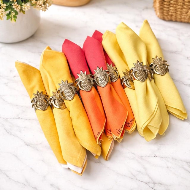 A complete set of 12 vintage solid brass pineapple napkin rings by Heyco, each cast with detailed pineapple leaves and...