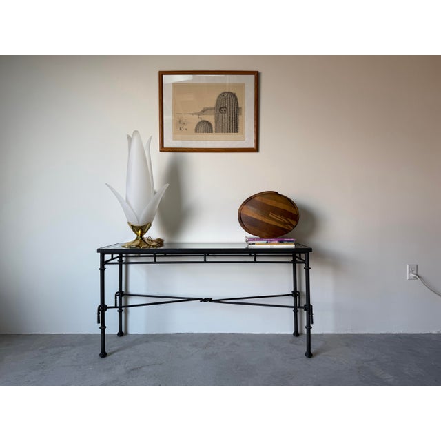 This striking 1980’s vintage console table features a sculptural Giacometti-style iron frame paired with a clean glass...