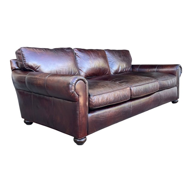Rich medium brown leather, feather-filled cushions, and an authentic aged patina define this vintage Restoration Hardware...