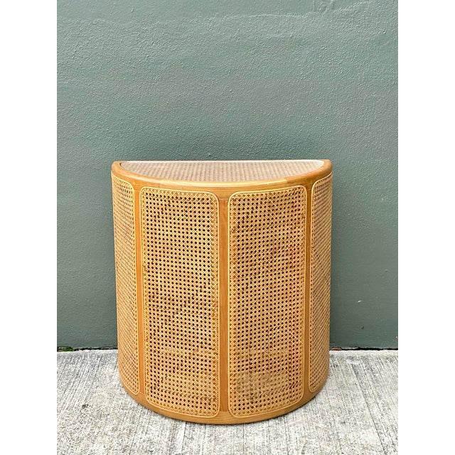 This vintage wood and cane demilune console table captures the effortless elegance of mid-century design through its...