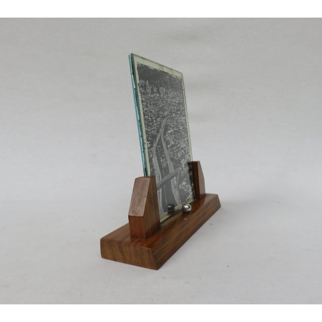 The base of the frame has a strict shape, with inlays in lighter colored wood. It features a chrome-plated ball which...