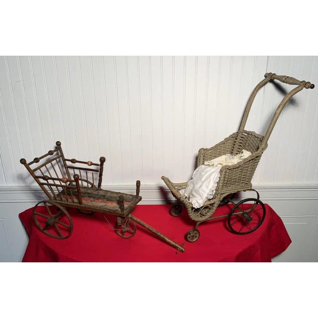 An early 20th century perambulator, pram or baby carriage with a carved push handle, wicker basket and steel and rubber...