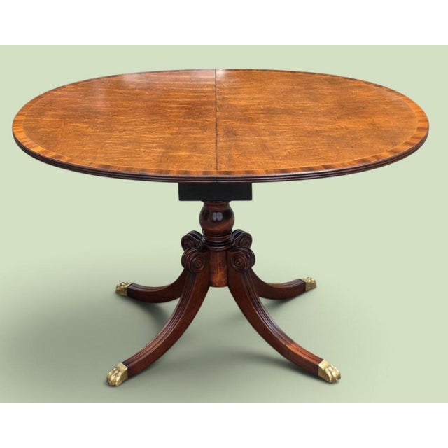 An elegant English Regency Revival oval extension dining table by the distinguished New York cabinetmakers Schmieg &...