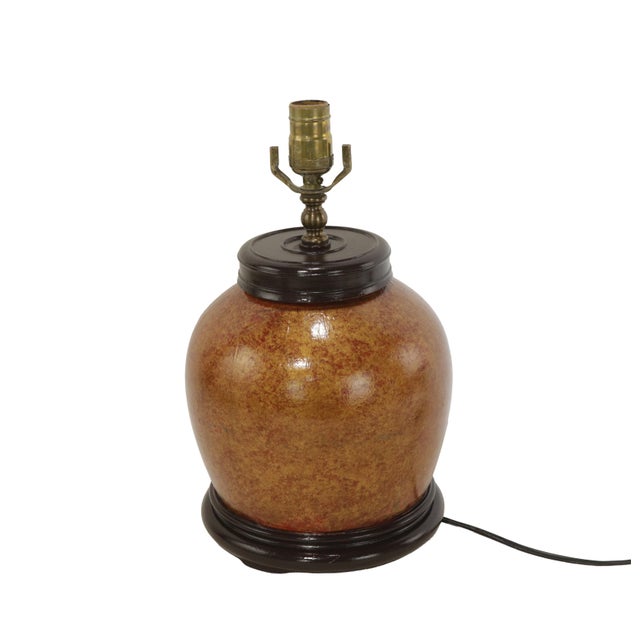 A red vintage ceramic table lamp with a unique brown and gold speckled glaze. This lamp has a retro style, with a...