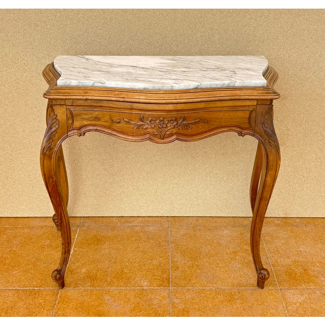 Elegant pair of French Louis XV style side tables, crafted from wood and featuring beautiful shaped marble tops. Each...