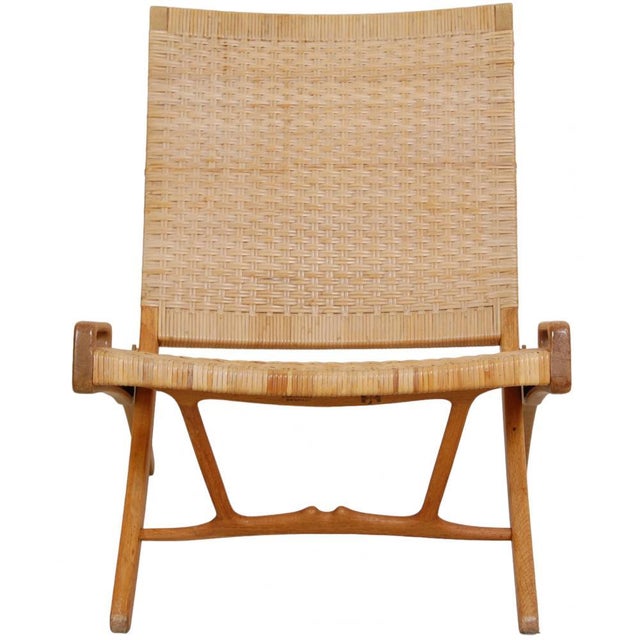 Hans J. Wegner lounge chair model JH-512 with a seat and backrest of wicker, and frame of oak. The chair is from the 60s...
